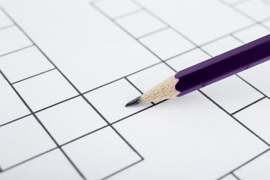 Photo of Pencil on blank crossword, closeup view. Space for text