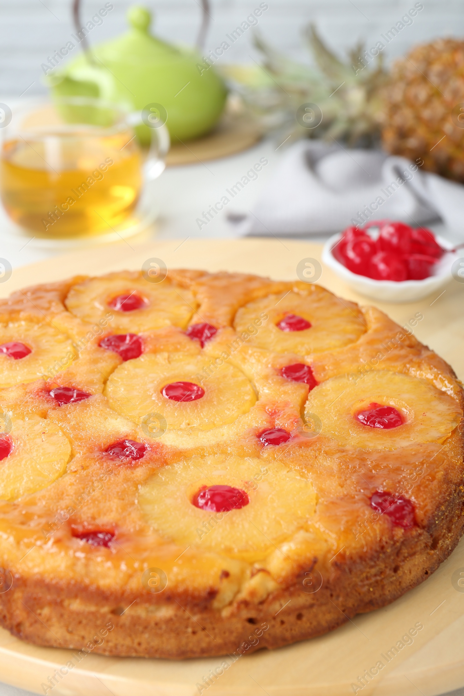 Photo of Tasty pineapple cake with cherries on table, closeup