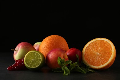 Photo of Many different fruits on table against black background