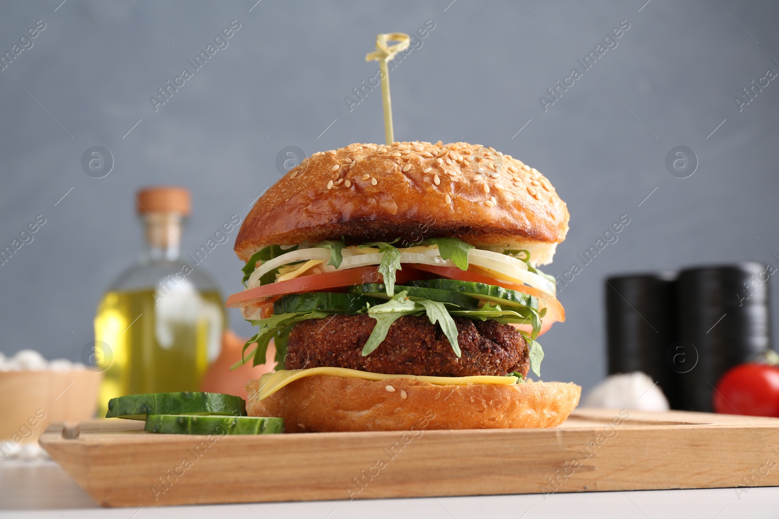 Photo of Board with delicious vegetarian burger on white table, closeup