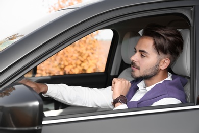 Photo of Young handsome man in driver's seat of modern car