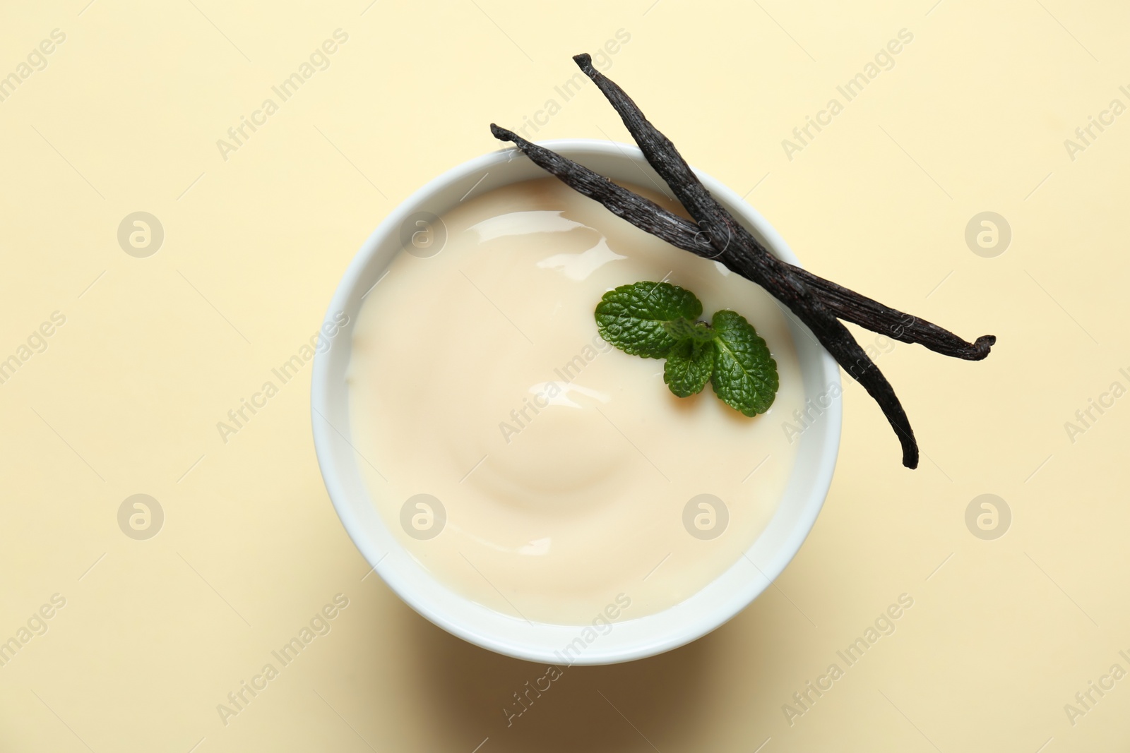 Photo of Vanilla pudding, sticks and fresh mint on color background