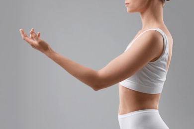 Photo of Sporty woman on grey background, closeup view