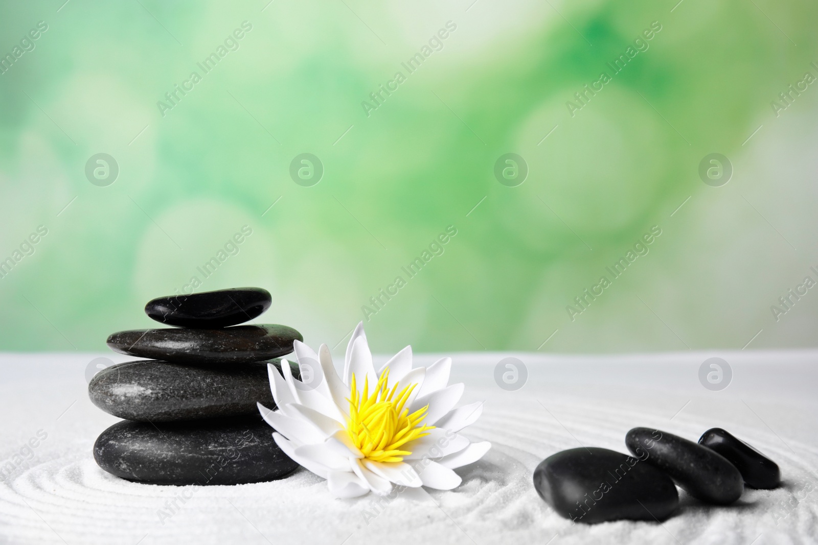 Photo of Zen garden. Beautiful lotus flower and stones on white sand, space for text