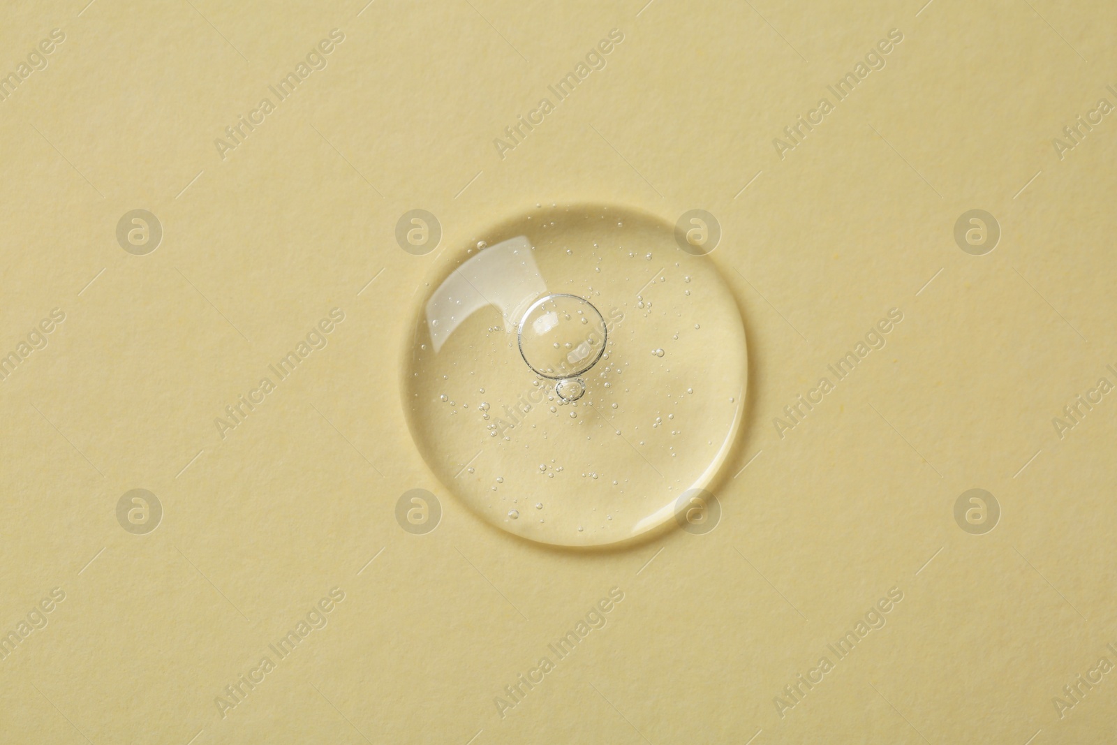 Photo of Sample of cosmetic serum on beige background, top view