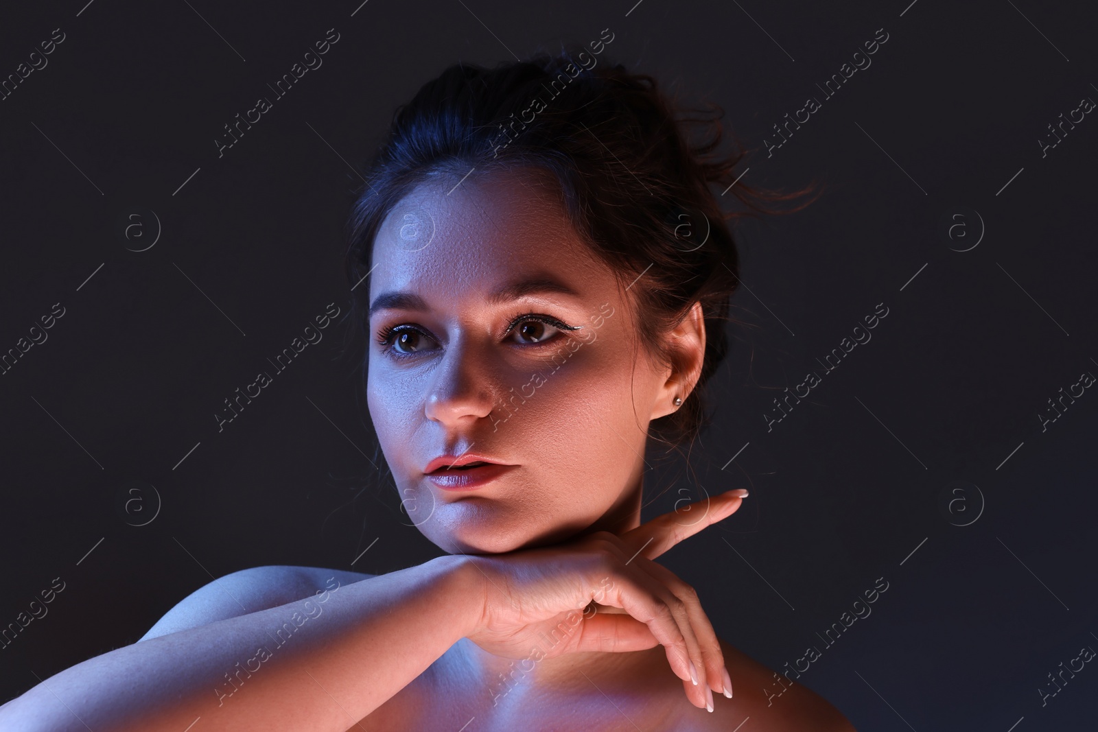 Photo of Portrait of beautiful young woman on dark background