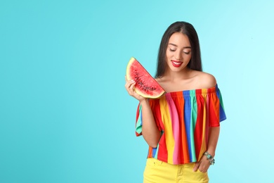 Beautiful young woman posing with watermelon on color background