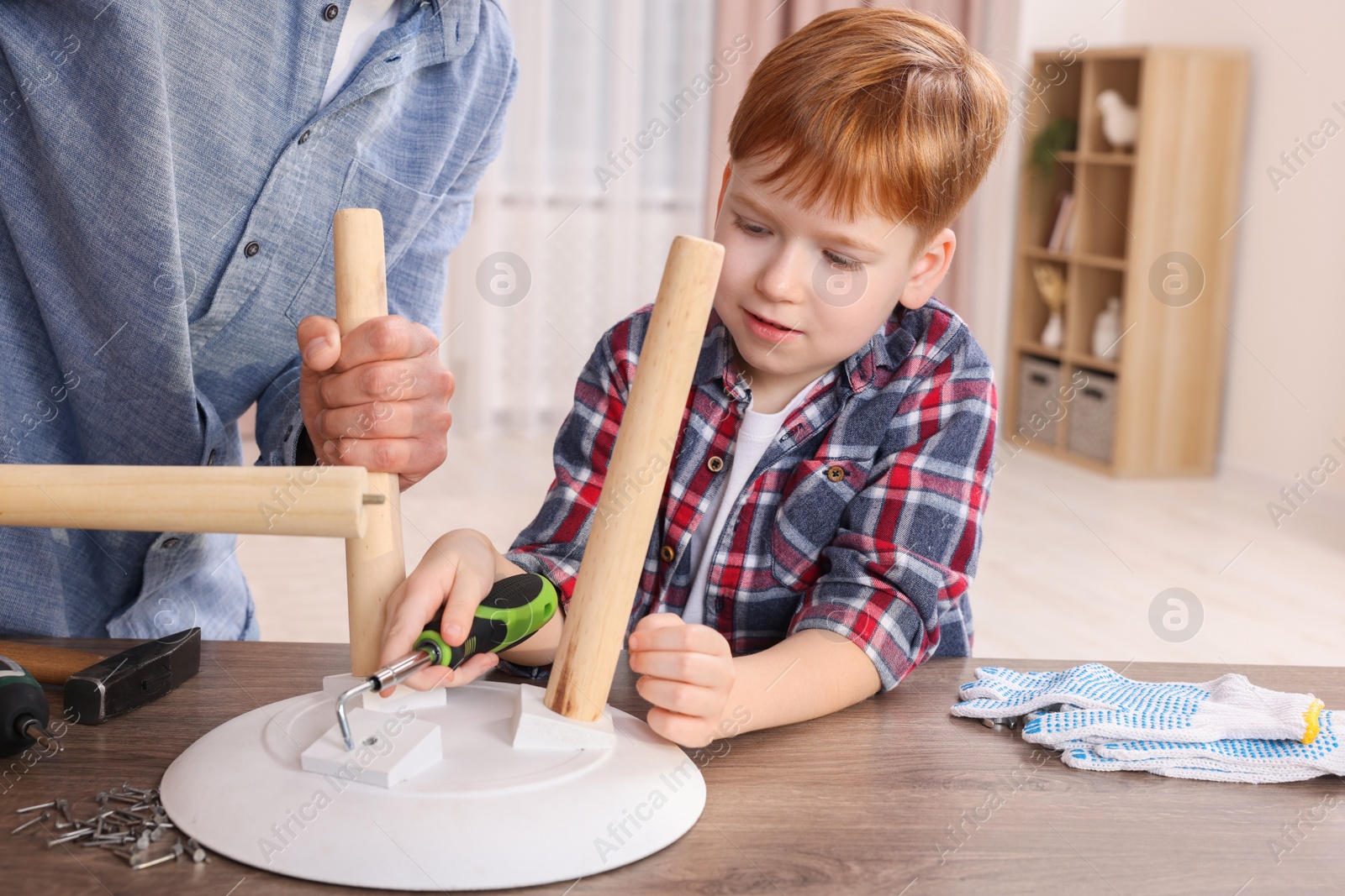 Photo of Father teaching son how to make stool at home, closeup. Repair work