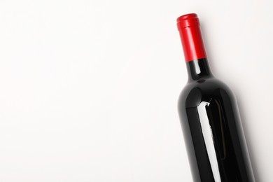 Photo of Bottle of expensive red wine on white background, top view. Space for text