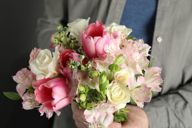 Man holding bouquet of beautiful flowers indoors, closeup