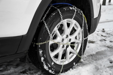 Car with snow chain on tire, closeup. Winter season