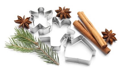 Photo of Different cookie cutters, cinnamon sticks, fir branch and anise stars on white background
