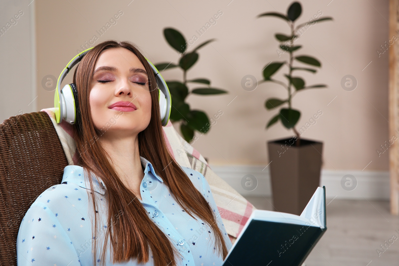 Photo of Woman listening to audiobook in chair at home