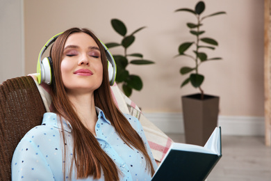 Photo of Woman listening to audiobook in chair at home