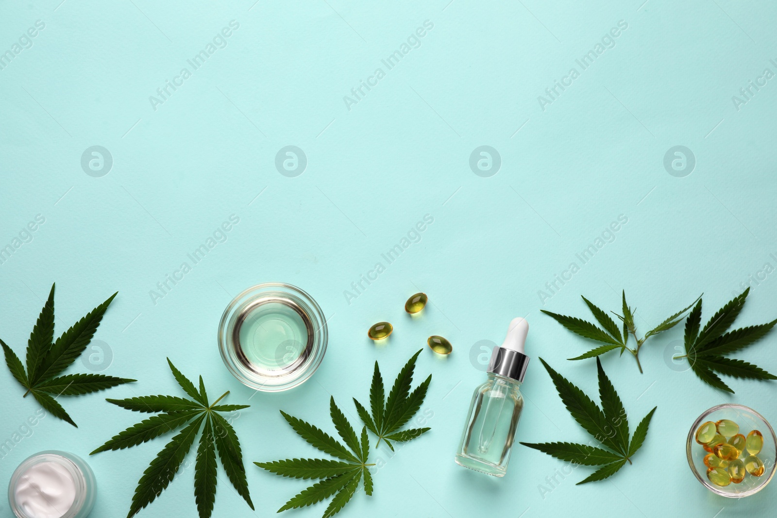 Photo of Flat lay composition with CBD oil or THC tincture and hemp leaves on light blue background, space for text