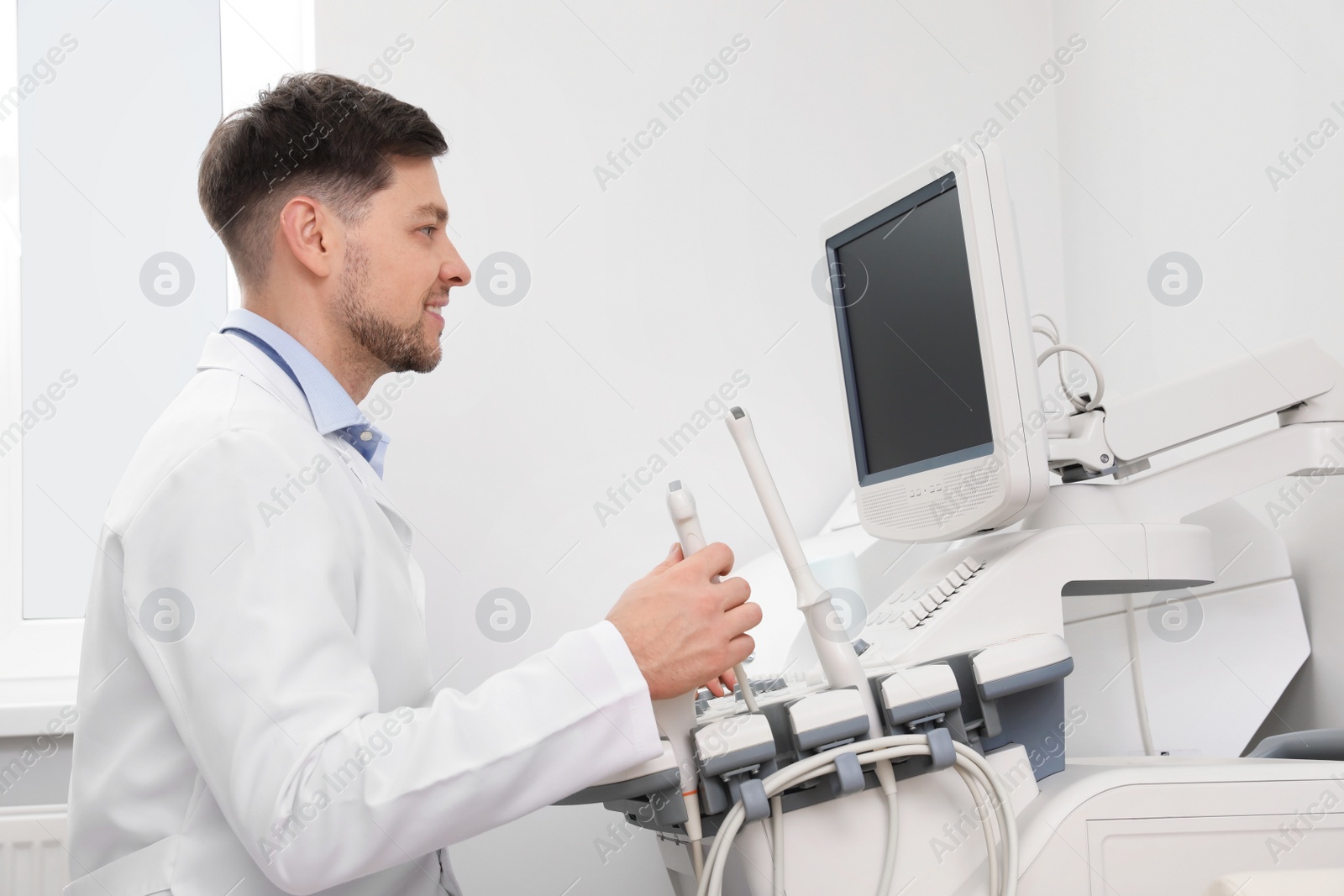 Photo of Sonographer operating modern ultrasound machine in clinic