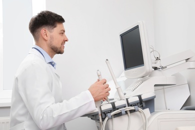 Sonographer operating modern ultrasound machine in clinic