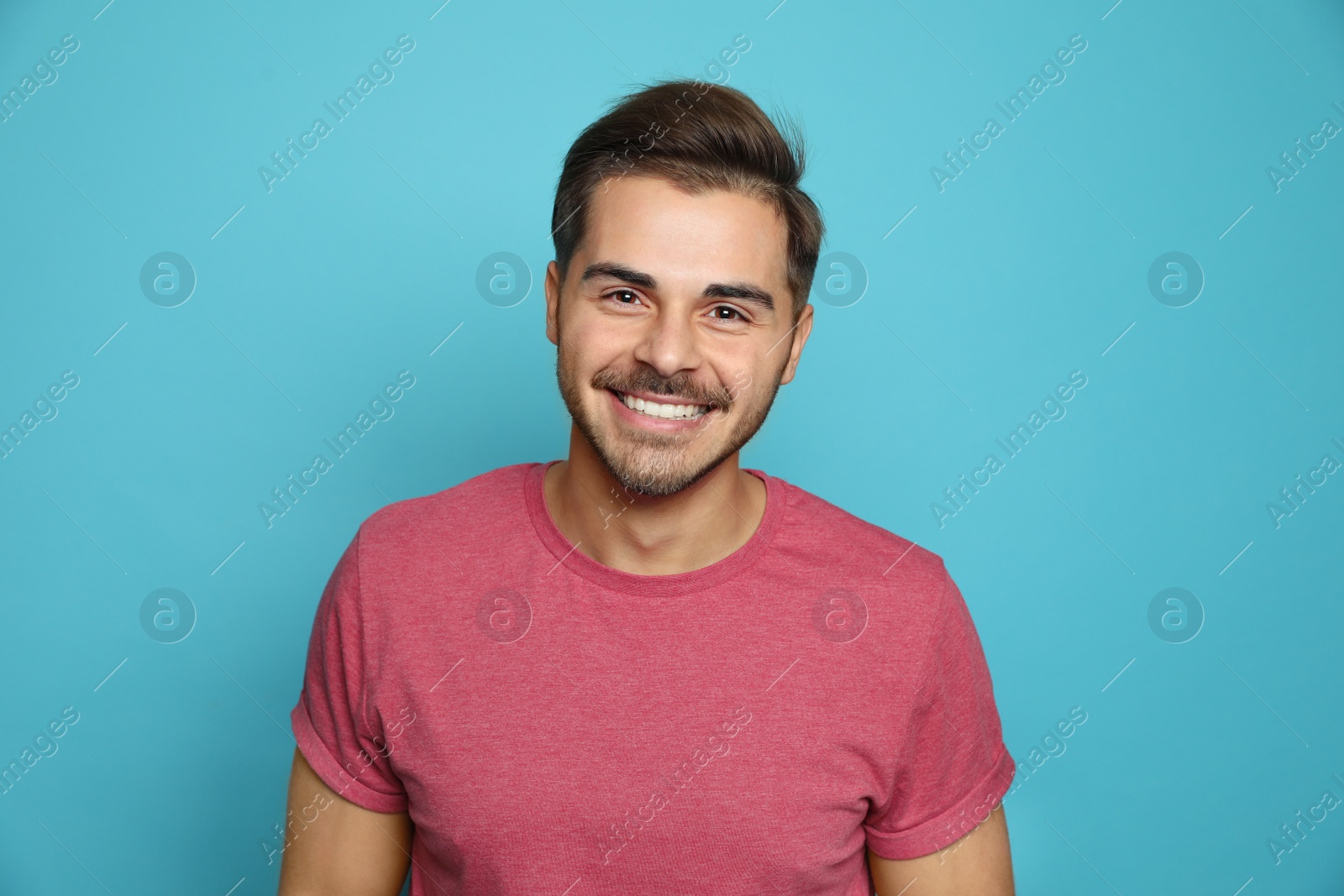 Photo of Handsome young man laughing against color background