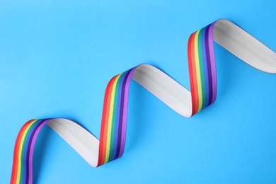 Photo of Bright rainbow ribbon on color background, top view. Symbol of gay community