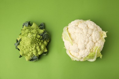 Photo of Fresh Romanesco broccoli and cauliflower on green background, flat lay