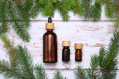 Photo of Flat lay composition with bottles of pine essential oil and conifer tree branches