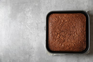 Homemade chocolate sponge cake on light grey table, top view. Space for text