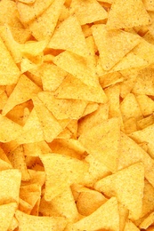 Photo of Tasty Mexican nachos chips as background, top view