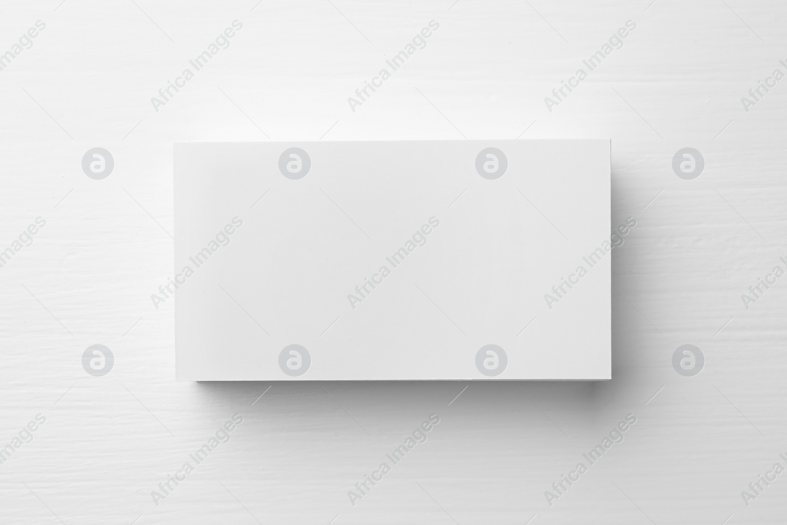 Photo of Stack of blank business cards on white table, top view. Mockup for design