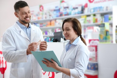 Portrait of professional pharmacists in modern drugstore