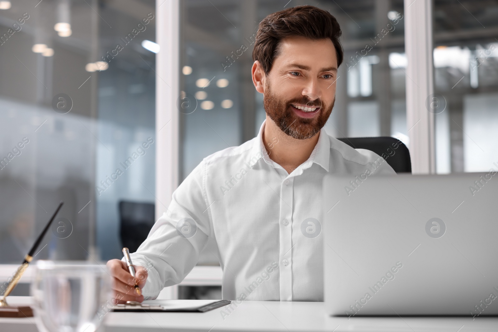 Photo of Portrait of smiling man working with laptop in office, space for text. Lawyer, businessman, accountant or manager