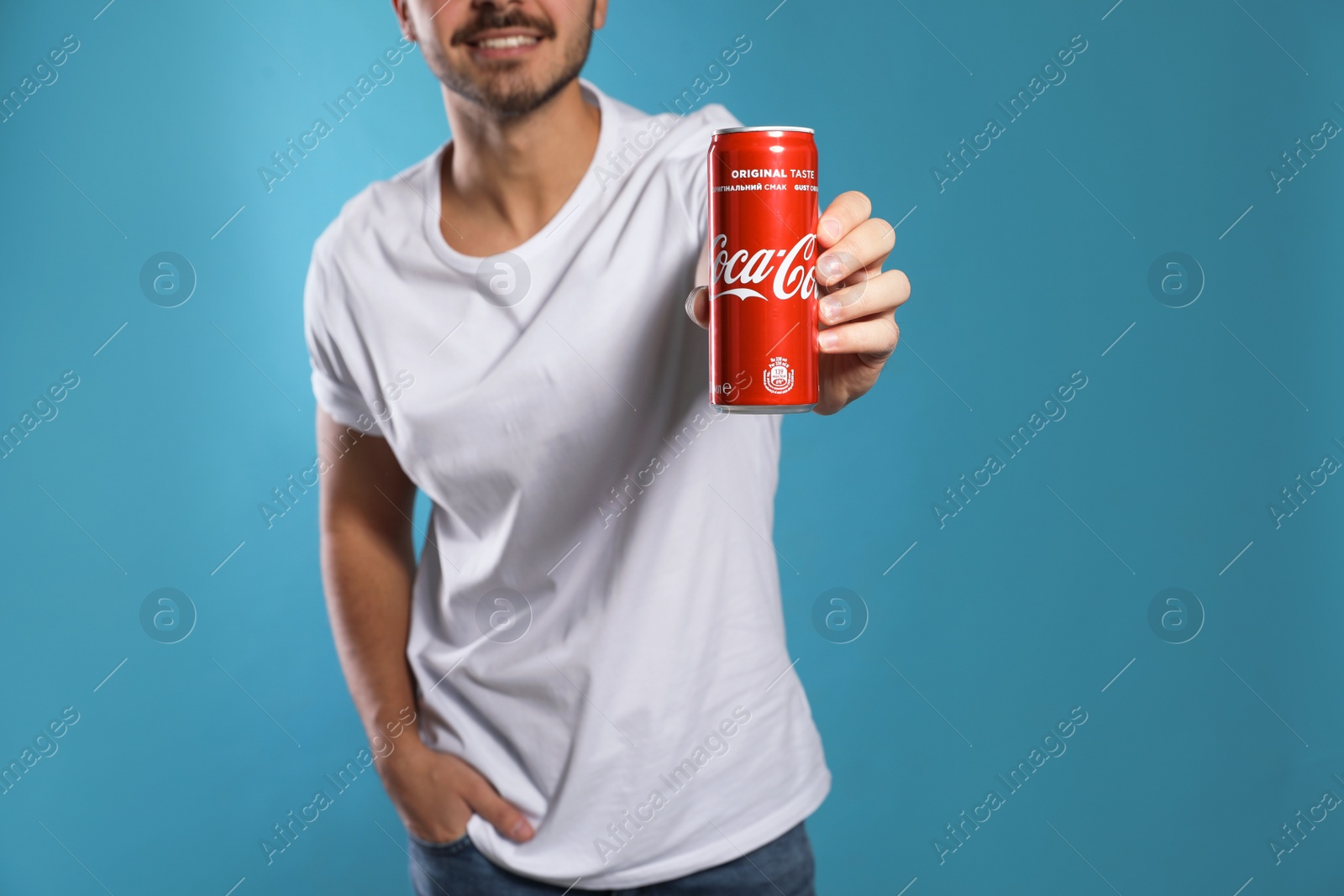 Photo of MYKOLAIV, UKRAINE - NOVEMBER 28, 2018: Young man with Coca-Cola can on color background, closeup. Space for text