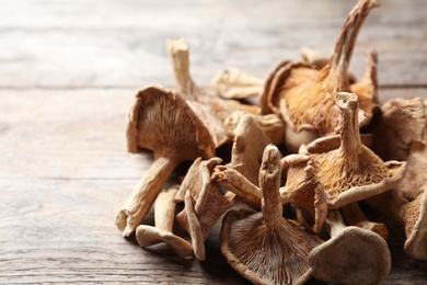 Photo of Delicious dried mushrooms on wooden background, closeup