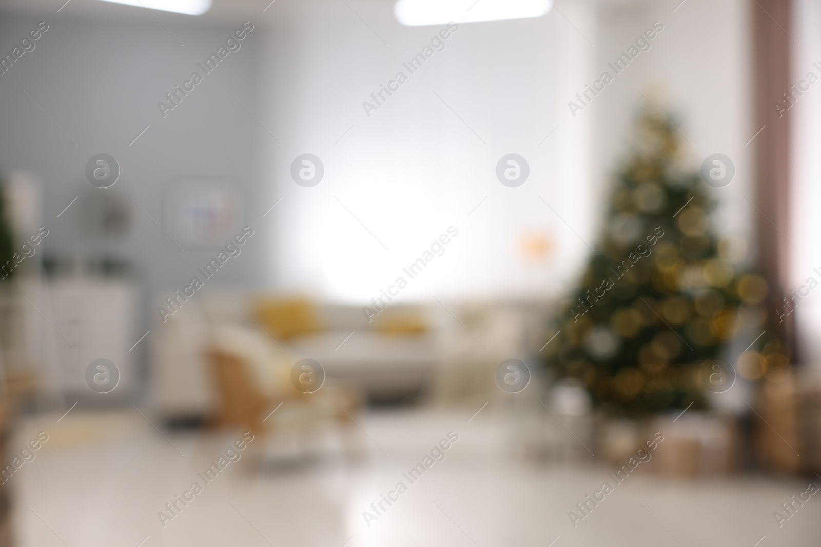 Photo of Christmas tree in furnished living room, blurred view. Festive interior design