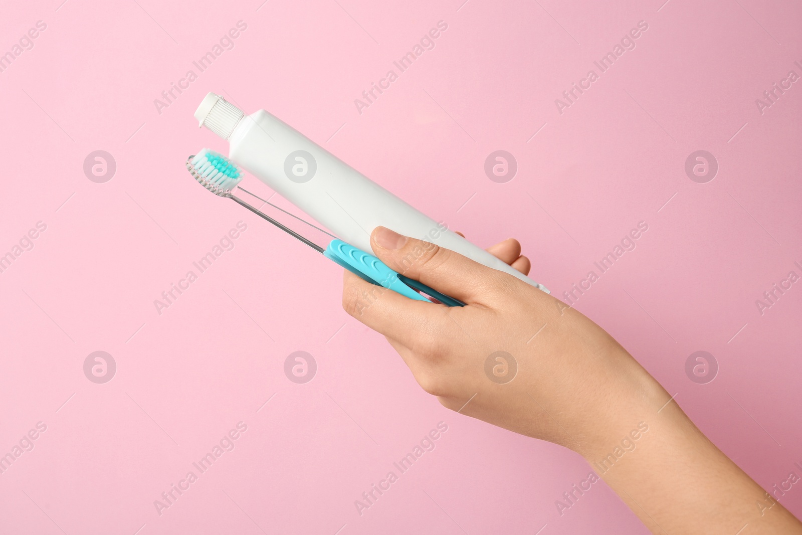 Photo of Woman holding toothbrush and paste against color background. Dental care