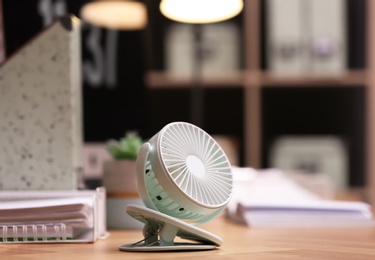 Photo of Modern electric fan on table in office