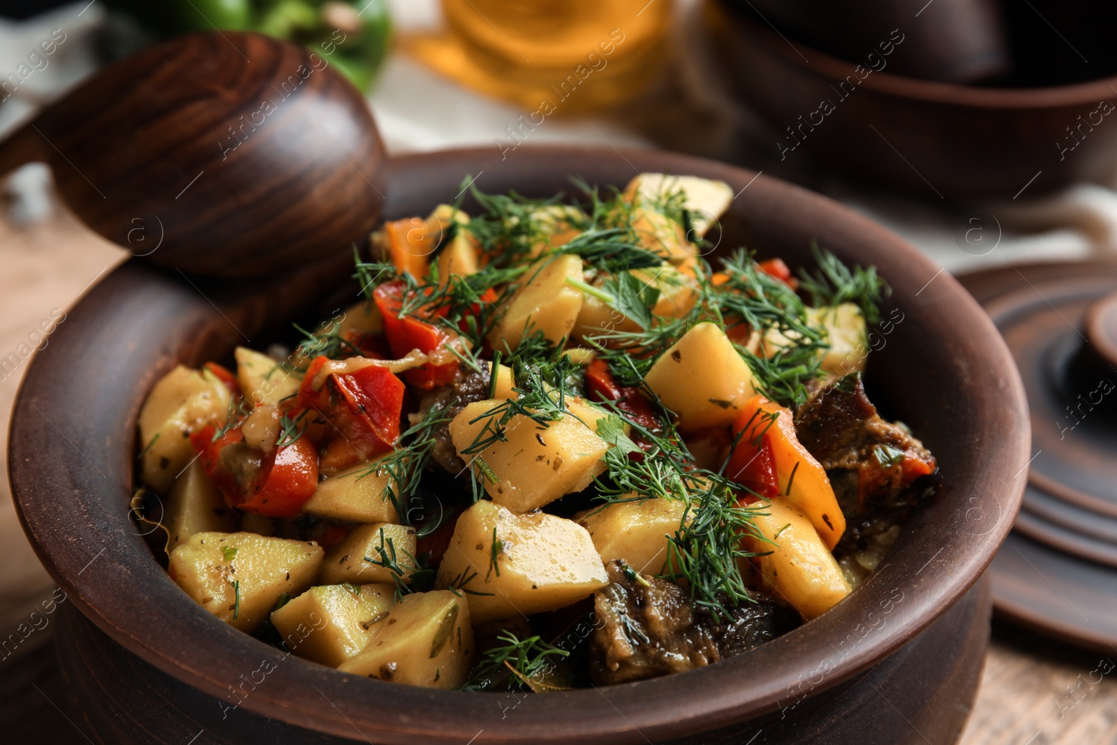 Photo of Tasty cooked dish with potatoes in earthenware, closeup