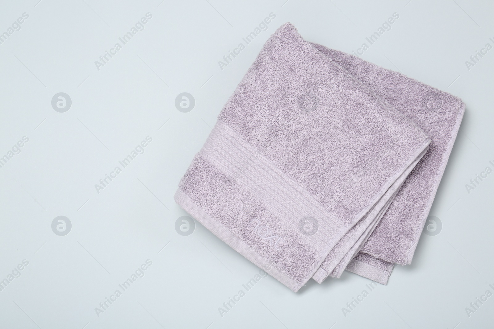 Photo of Violet terry towel on light grey background, top view. Space for text