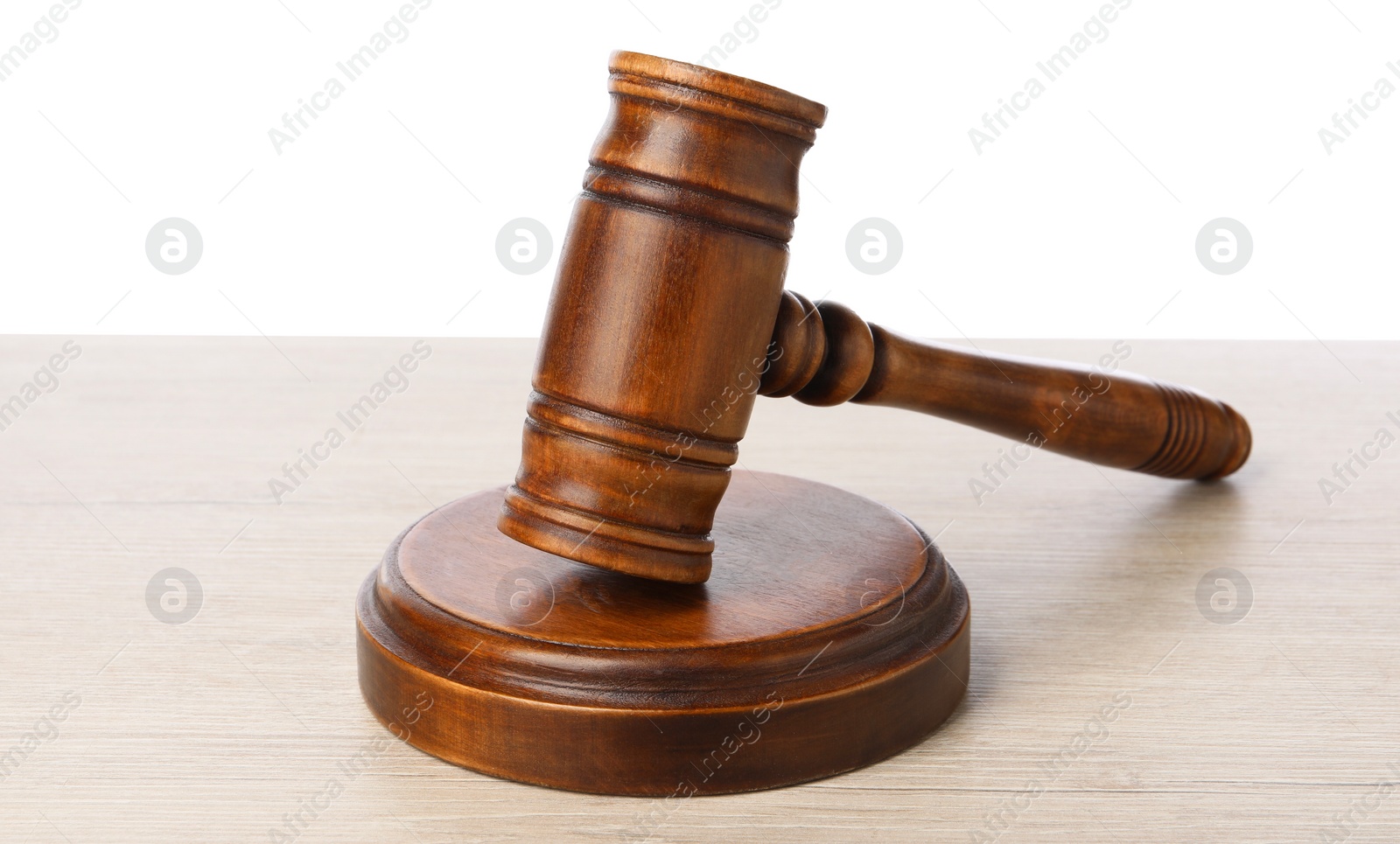 Photo of Wooden gavel on light table against white background