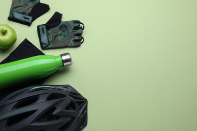 Photo of Flat lay composition with different cycling accessories and clothes on light background, space for text