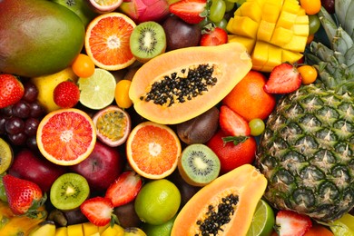 Photo of Many different delicious exotic fruits as background, top view