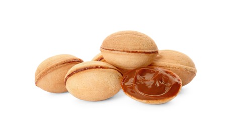 Photo of Delicious nut shaped cookies with boiled condensed milk on white background