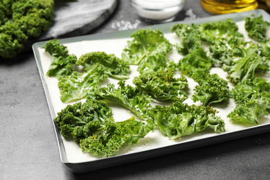 Photo of Raw cabbage leaves on grey table, closeup. Preparing kale chips