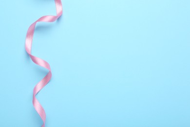 Beautiful pink ribbon on light background, top view. Space for text
