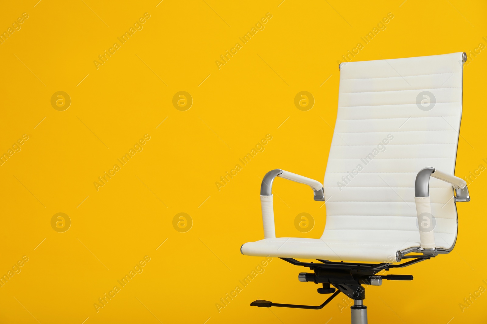 Photo of Modern office chair on yellow background. Space for text