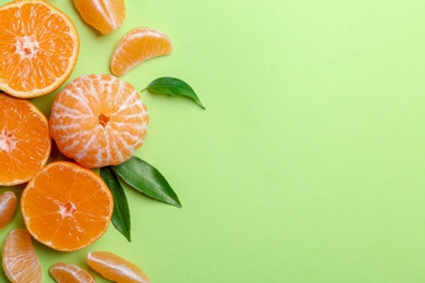 Composition with tangerines and leaves on color background, flat lay. Space for text