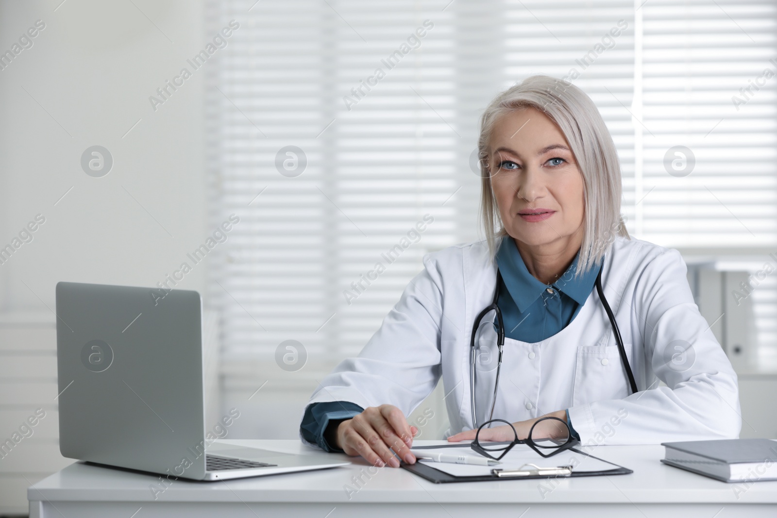 Photo of Portrait of mature female doctor in white coat at workplace