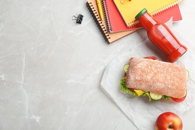 Flat lay composition with appetizing food and stationery on light background