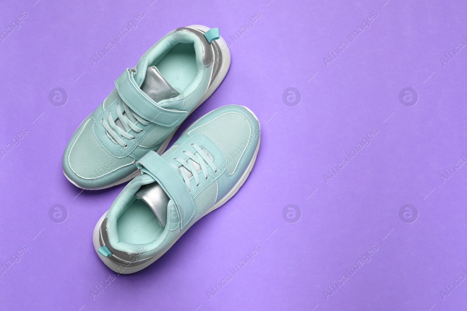 Photo of Pair of comfortable sports shoes on violet background, flat lay. Space for text