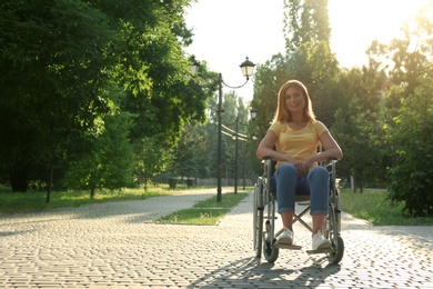 Photo of Happy woman in wheelchair at park on sunny day. Space for text