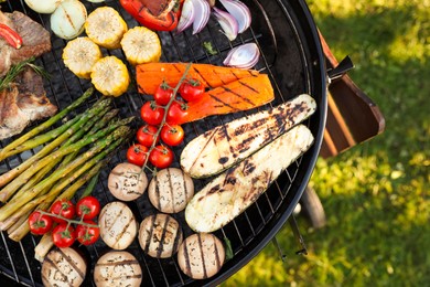 Delicious grilled vegetables and meat on barbecue grill outdoors, top view